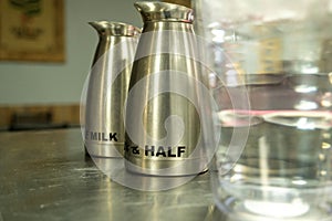 Milk and Half and Half pitchers in a coffee shop