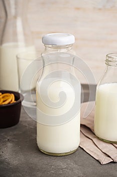 Milk in jar and glass on the grey background. Close-up.