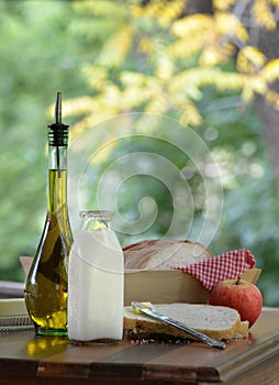 Milk jug olive oil homemade bread and apple picinic with vintage outdoor style