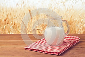 Milk jug over wheat field background