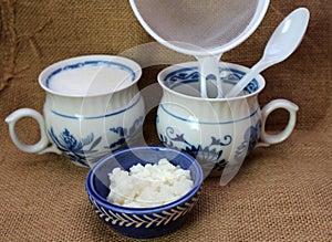 Milk kefir grain and fresh homemade kefir fermented milk with plastic sieve and spoon
