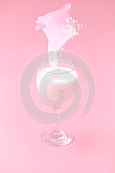 milk with oatmeal is poured into a glass. pink background.