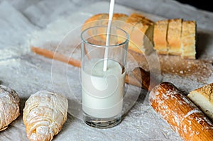 Milk is poured into a glass, bread, croissants