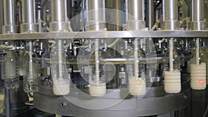 Milk pouring into bottles on a industrial equipment at a milk production factory.