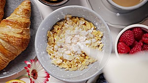 Milk pouring into bowl full of corn flakes with splashing. Healthy breakfast concept