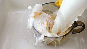 Milk pouring into corn flakes and strawberries bowl in slow motion.