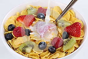 Milk pouring into fruit muesli