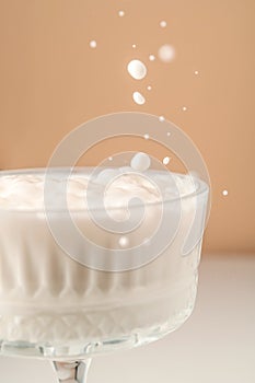 Milk pours into a beautiful crystal glass and splashes around.