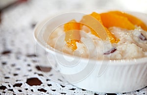 Milk rice pudding dessert with raisins and orange