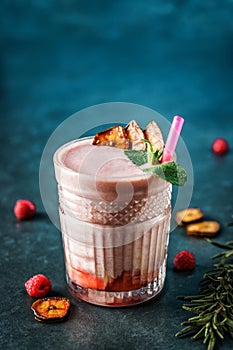 Milk smoothie strawberry, banana, raspberries in glass on dark blue background. Summer cold drink and healthy breakfast