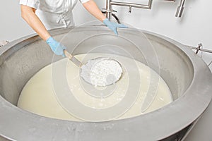 Hands work on cheese production