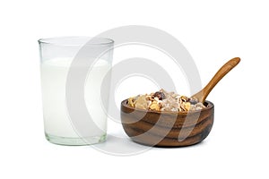 Milk in transparent glass and muesli multi fruit in wooden bowl