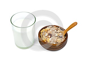 Milk in transparent glass and muesli multi fruit in wooden bowl and spoon isolated on white background ,include clipping path