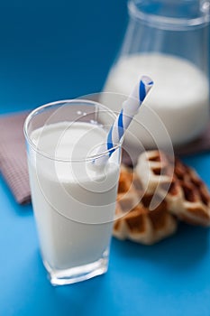 Milk with wafer on blue background