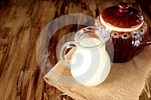 Milk whey in a glass jug and a clay pot