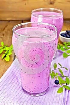 Milkshake with blueberries in glasses on board