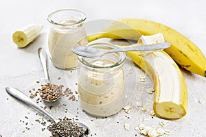 Milkshake with chia and banana in jars on granite table