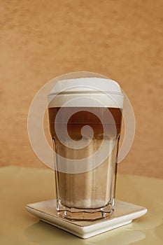 Milkshake or coffee served in a glass with lid