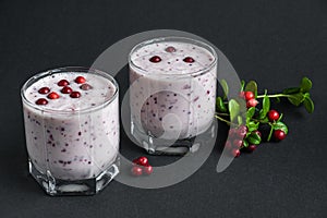 Milkshake with fresh lingonberries on a dark background. Berry smoothie. Healthy food, detox or diet concept. Copy space