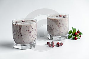 Milkshake with fresh lingonberries, on a white background. Berry smoothie.Healthy food, detox or diet concept.Soft focus