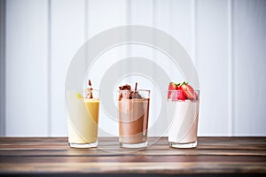 milkshake trio: chocolate, strawberry, vanilla in aligned glasses