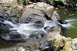 Milky flowing waters and rocks of waterfall