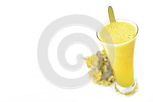 Milky fruit smothie served on a iced glass against a white background.