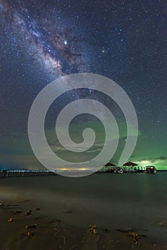 The Milky Way is above the bridge that stretches out into the sea