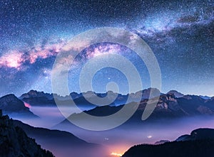 Milky Way above mountains in fog at night in autumn