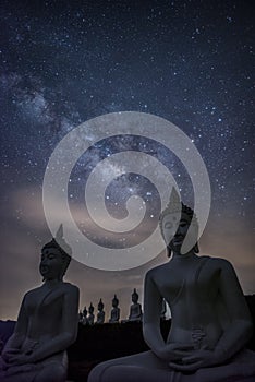 Milky way galaxy over many of buddha statues at Phu Phra Ban Mak Khaeng, Dan Sai, Loei, Thailand. Vertical photo