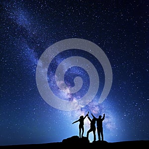 Milky Way. Night sky with silhouette of a happy family