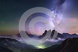 Milky Way over mountains in fog at night in summer. Landscape with foggy alpine mountain valley