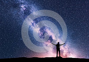 Milky Way and silhouette of a standing happy man