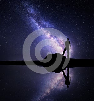 Milky Way and silhouette of a standing man near river