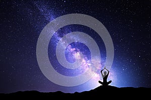 Milky Way and silhouette of a woman practicing yoga