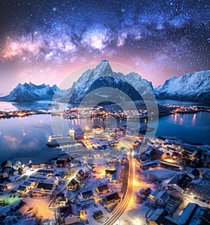 Milky Way, snowy village, sea, mountain, sky at winter night