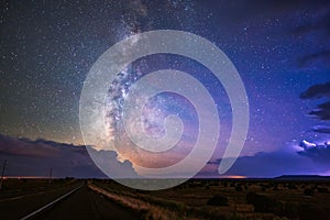 The Milky Way and starry night sky between thunderstorm clouds.