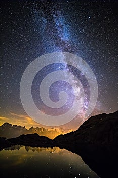 Milky Way and Starry Sky over Iconic Snowy Mont-Blanc Peaks Reflecting in Altitude Lake