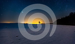 Milky way and starry sky over winter landscape and distant village