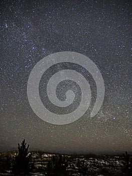 Milky way stars on night sky and snow on sea coast