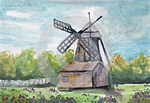 The mill on flowers` field on the background with green trees and blue sky