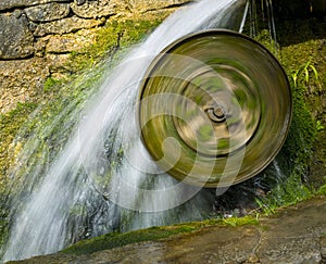 , a mill wheel spins fast from the water