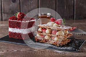 Mille feuille dessert sweet slice red velvet cake with white frosting is garnished with strawberries