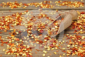 Milled Chili Peppers Flakes And Corns On Wooden Board photo