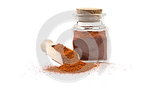 Milled or ground paprika or red pepper in wooden scoop and jar on isolated on white background. front view. spices and food ingred