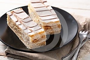 Millefoglie or French mille-feuille on white wood photo