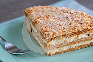 Millefoglie or mille-feuille pastry on a plate, powdered sugar