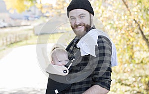 Millenial Dad with Baby in Carrier Outside Walking photo