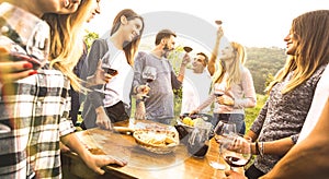 Millenial friends having fun time drinking red wine oudoors - Happy fancy people enjoying harvest at farmhouse vineyard winery -