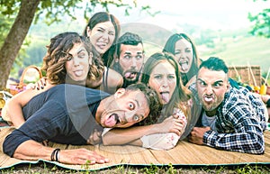 Millenial friends taking selfie with funny faces at pic nic barbecue - Happy youth friendship concept with millennial young people photo